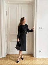a lady in a black crop jacket with a black a-line skirt